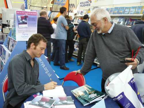 Jon Emmett signing copies of Be Your Own Sailing Coach at the  Dinghy Show.